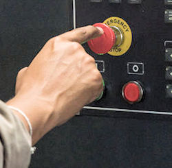 Image of assigned employee delaying exit to push an emergency shut off button