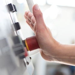 Image of an trained employee pushing an emergency shutoff button in response to an emergency.