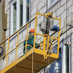 Two workers on a suspended scaffold using the rope descent system.