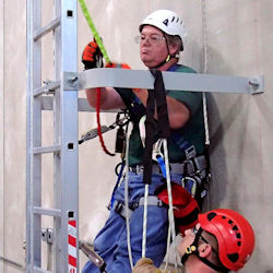 Worker receiving fall protection equipment training.