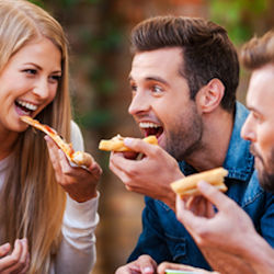 Employees enjoying pizza together.