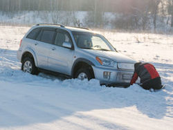 Driver trying to dig car out of snow.