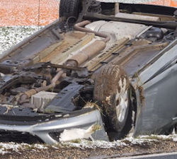 car that is upside down in a snowy ditch