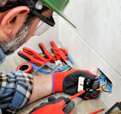 employee working on an electrical outlet