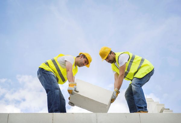 Two workers carrying a heavy load together