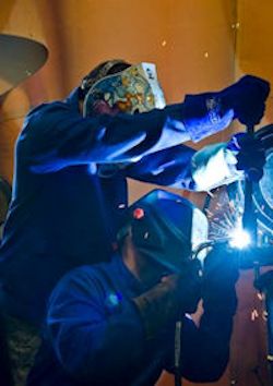 two welders working together