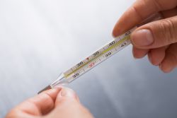 Employee holding mercury thermometer