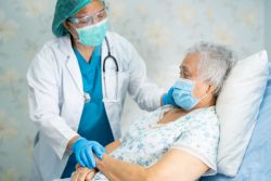 Nurse wearing PPE while checking on patient