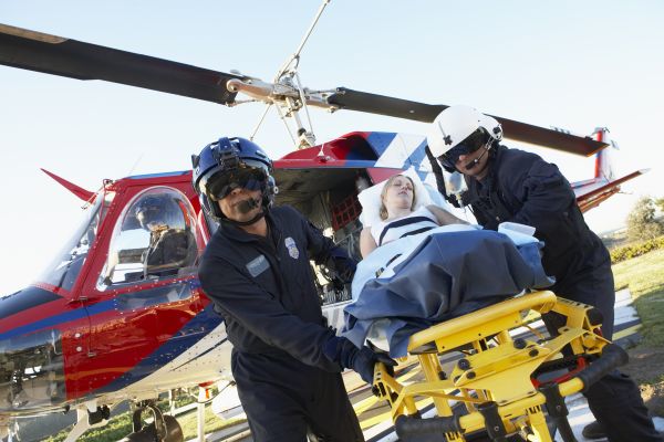 Paramedics In Flight Gear Unloading A Patient From A Helicopter