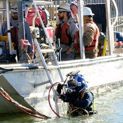 A diver enters the water to assist with the placement of the 10th and final concrete shell on the riverbed of the Tennessee River below Kentucky Lock in Grand Rivers, Ky. USACE Photo Mark Rankin.