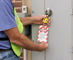 Authorized employee applying a lockout device to door handle