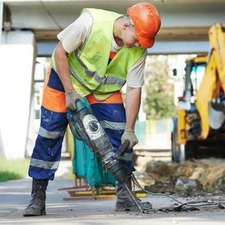 USACE employee using jackhammer on floor