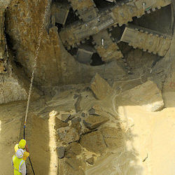 Two workers working in by enormously large Tunneling Machine