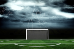 darkened sky with lightning at a soccer field