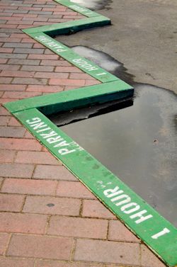 school curb painted green indicating limited time parking