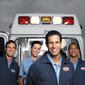 Four emergency medical technicians (EMTs) with an ambulance in the background.