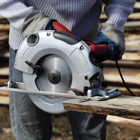 Circular saw cutting through a wood board.