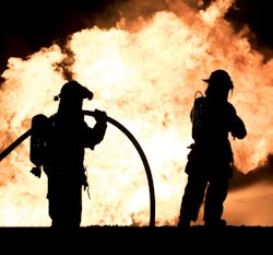 Two firefighters facing a big fire.