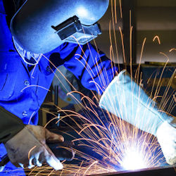 Welder wearing full PPE working with sparks flying