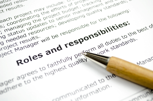 The words Roles and Responsibilities on a piece of paper with a pen pointing at the words.