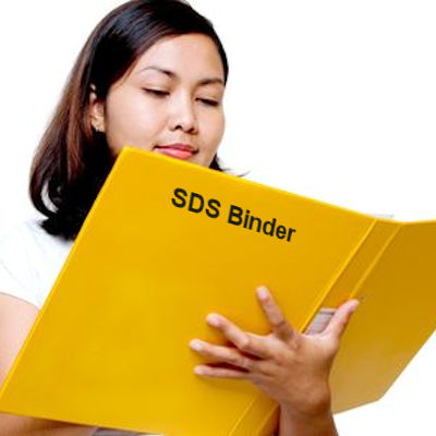 Woman reading a yellow binder with the words SDS Binder