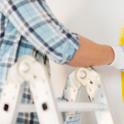 Worker standing on an articulated ladder with locking hinges.