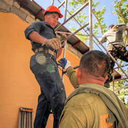 Worker standing on scaffolding with a qualified person training them.