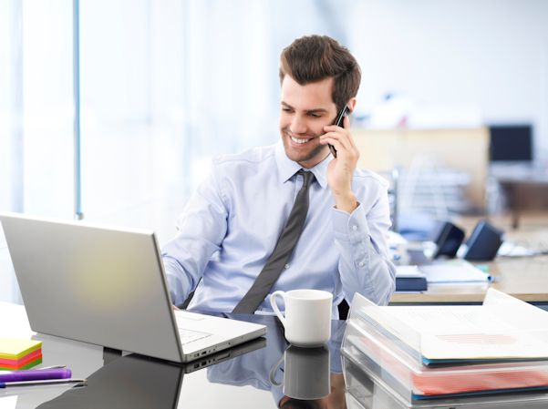 Office worker at desk looking at laptop computer