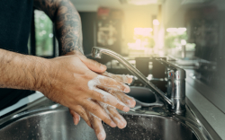 Tattoo artist washing hands with water and soap