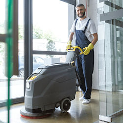 Worker with gloves using heavy duty electric Floor scrubber