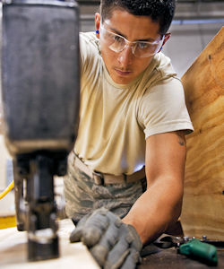 Worker using nail gun in awkward posture and extended reach