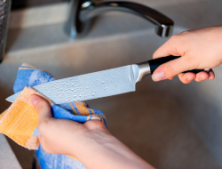 Employee drying a knife with a towel.