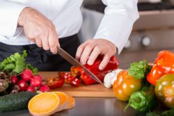 Chef cutting a pepper with a knife.