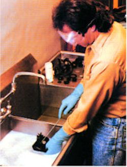 Worker using soap and water to clean respirators. Disinfectant also necessary