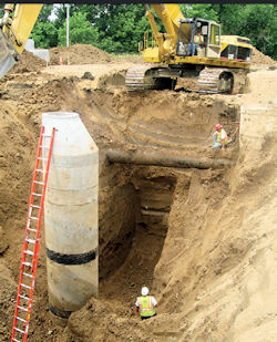 Worker in an large deep unprotected trench.