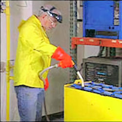 worker adding water to forklift batteries