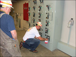 Oncoming crew chief attaching LOTO while another employee looks on.