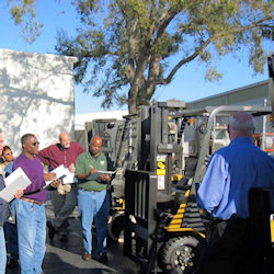 Competent person giving forklift training to a group of employees