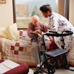 A caretaker helping an elderly patient in a nursing home.