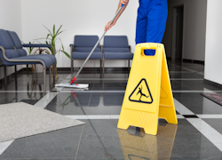 employee mopping floor near a mat.