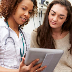 A doctor and a patient looking at a tablet.