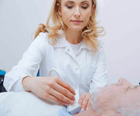 Ultrasound tech performing an ultrasound on patients neck.