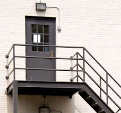 An exterior view of an exit door that opens out to a stairwell.