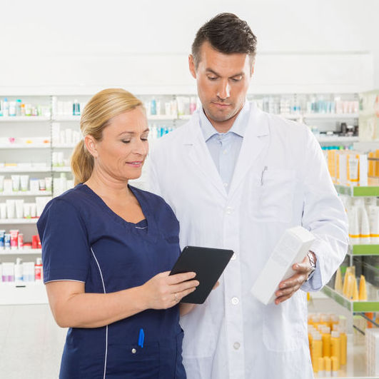 Pharmacist speaking with a doctor about medication.