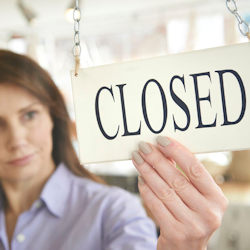 Shop owner putting up store closed sign