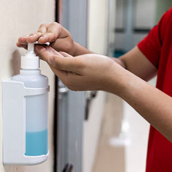 Image of an employee using hand sanitizer