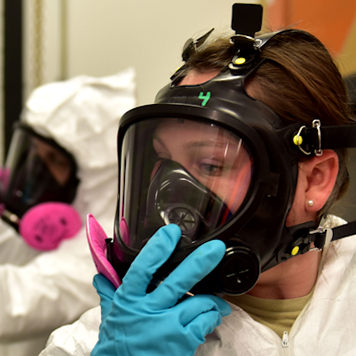 Image of an employee conducting a respirator inspection