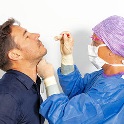 Nurse administering a covid-19 PCR test on a patient