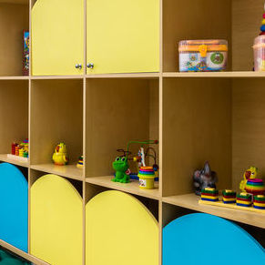 Cubby storage shelves with blue and yellow doors on some of the cubbies.