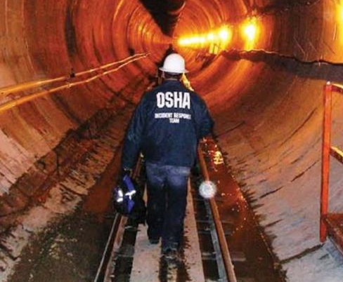 OSHA enforcement officer inspecting a tunnel